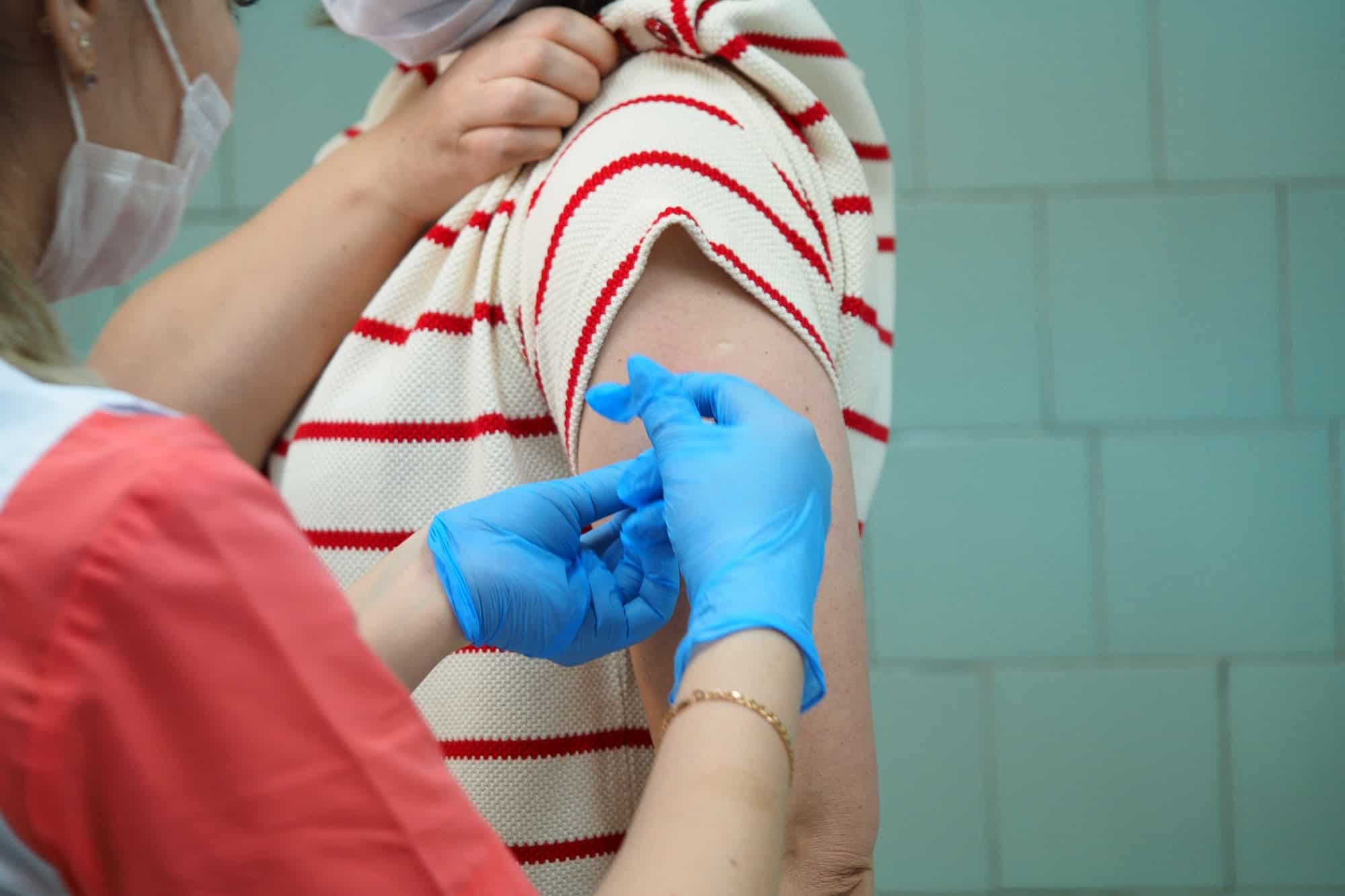 Vaccination Coronavirus infection, Covid 19. A nurse makes a vaccination in the patient's shoulder.